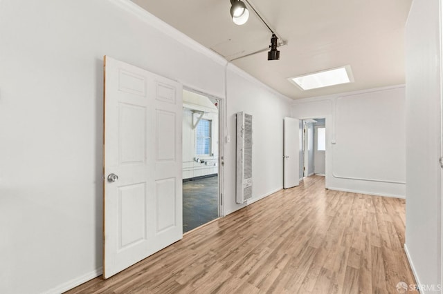 737 Minna St, San Francisco, CA 94103 - empty room featuring a heating unit, a skylight, ornamental molding, and light wood-style floors