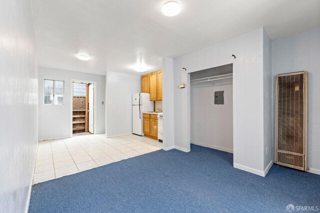 737 Minna St, San Francisco, CA 94103 - unfurnished living room featuring light tile patterned flooring, light colored carpet, a heating unit, stairs, and baseboards