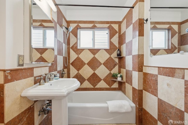 full bath featuring a healthy amount of sunlight, tile walls, and a tub to relax in