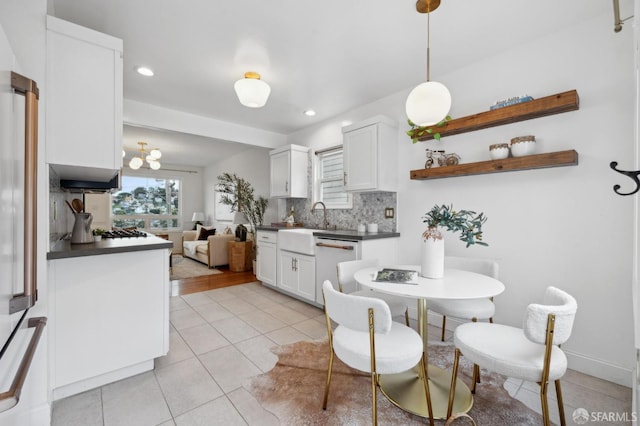 kitchen featuring tasteful backsplash, dark countertops, white appliances, white cabinets, and light tile patterned floors