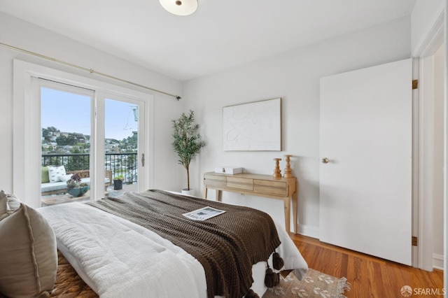 bedroom with wood finished floors and access to outside