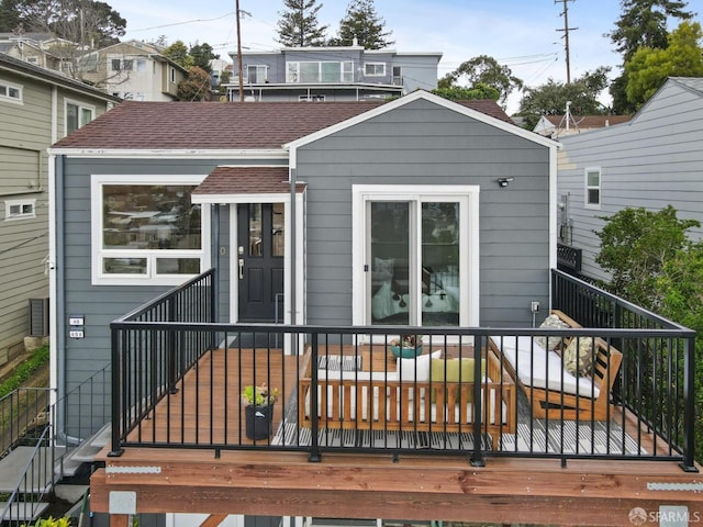 back of house featuring a shingled roof