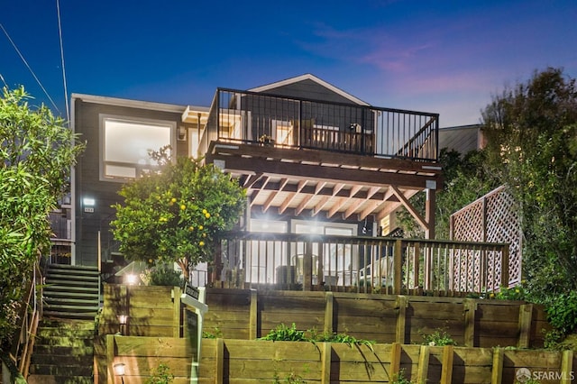 back of property featuring stairway and a balcony