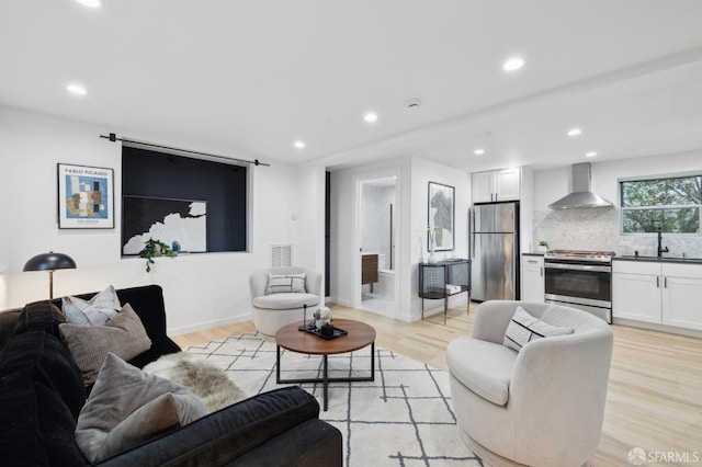 living room featuring recessed lighting, baseboards, and light wood-style floors