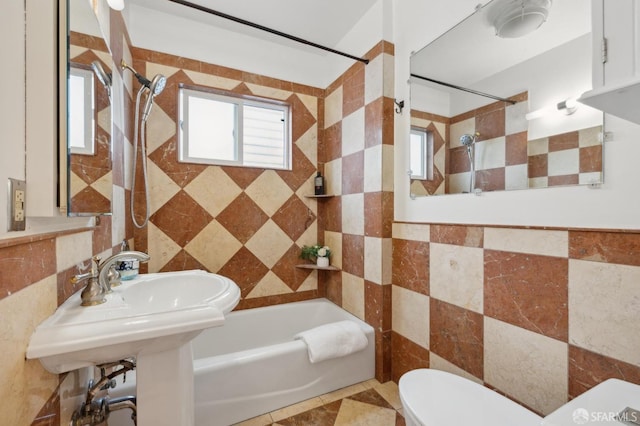 bathroom featuring shower / washtub combination, toilet, and tile walls