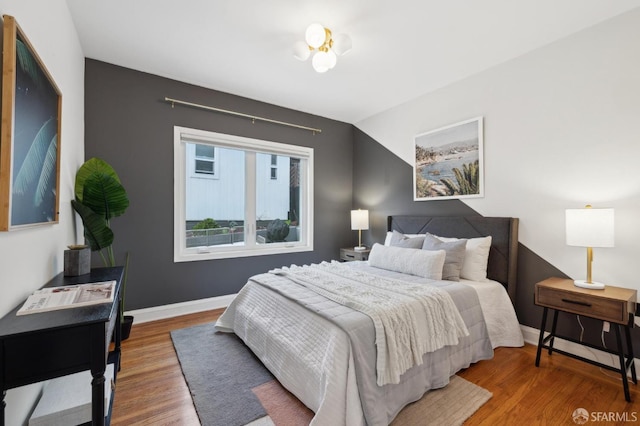 bedroom with baseboards and wood finished floors