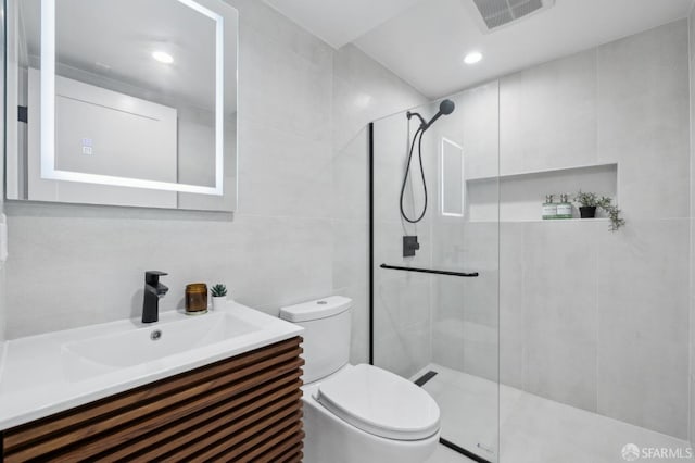 full bath with vanity, visible vents, tiled shower, tile walls, and toilet