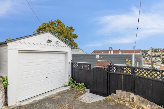 detached garage featuring a gate and fence