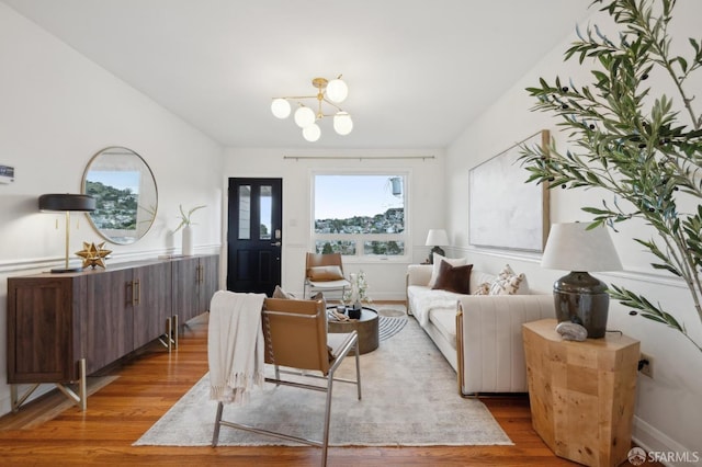 living area featuring an inviting chandelier and wood finished floors