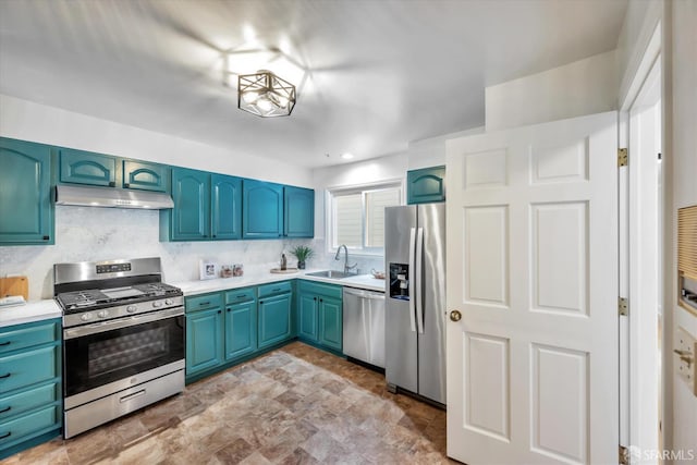 kitchen featuring under cabinet range hood, a sink, blue cabinetry, appliances with stainless steel finishes, and decorative backsplash