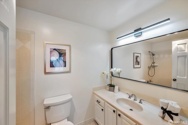 bathroom featuring toilet, a shower, and vanity