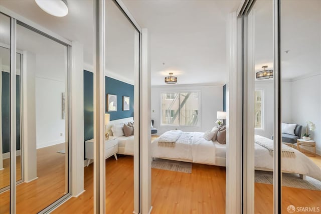 bedroom featuring light wood finished floors and ornamental molding