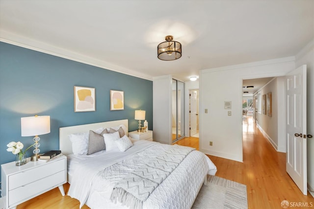 bedroom featuring baseboards, a closet, and light wood-style floors