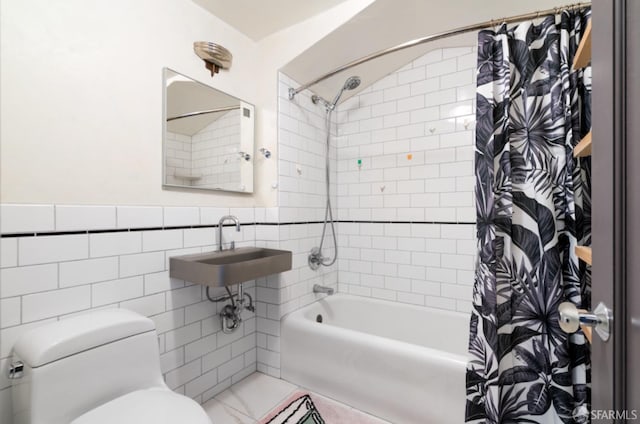 full bathroom featuring sink, shower / bath combination with curtain, tile walls, and toilet