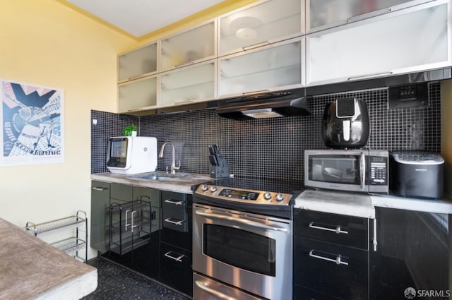 kitchen with appliances with stainless steel finishes, backsplash, and sink