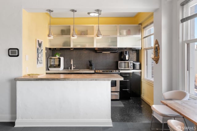 kitchen featuring sink, stainless steel appliances, range hood, kitchen peninsula, and decorative light fixtures