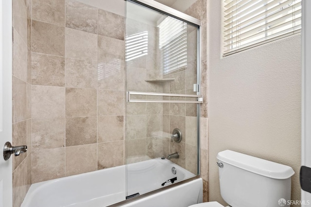 bathroom with toilet, bath / shower combo with glass door, and plenty of natural light