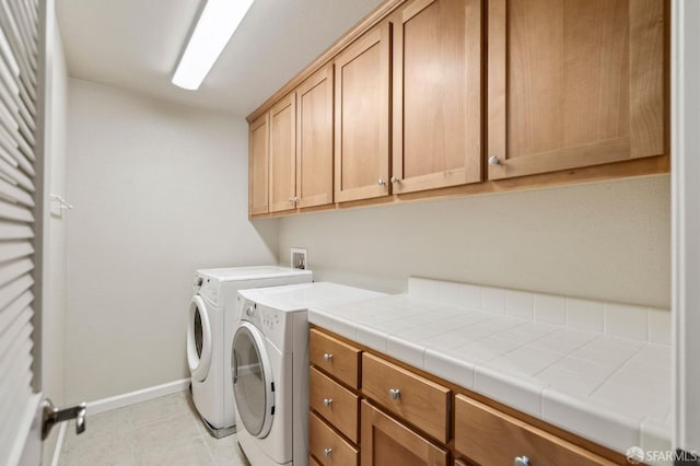 laundry room featuring cabinets and washer and dryer