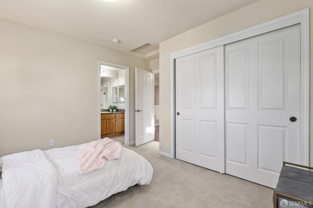 carpeted bedroom with a closet and connected bathroom