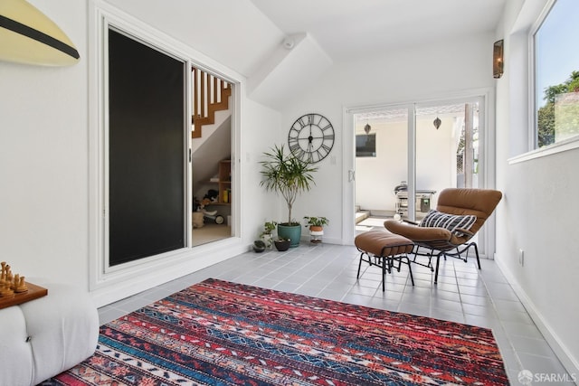 sitting room featuring lofted ceiling, tile patterned floors, and baseboards