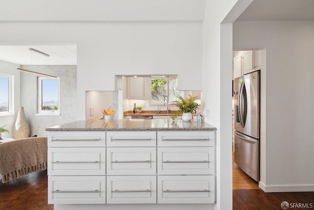 kitchen featuring dark wood-type flooring, white cabinets, light stone counters, and stainless steel fridge with ice dispenser
