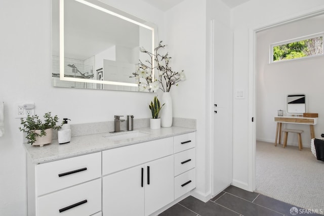 bathroom featuring tile patterned floors, baseboards, vanity, and a tile shower
