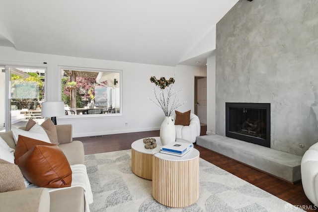 living area with high vaulted ceiling, a premium fireplace, wood finished floors, and baseboards