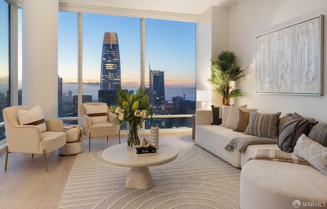 living room featuring a view of city, wood finished floors, and a wall of windows