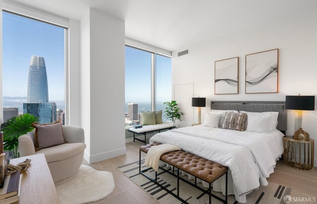 bedroom featuring multiple windows, light wood finished floors, and visible vents