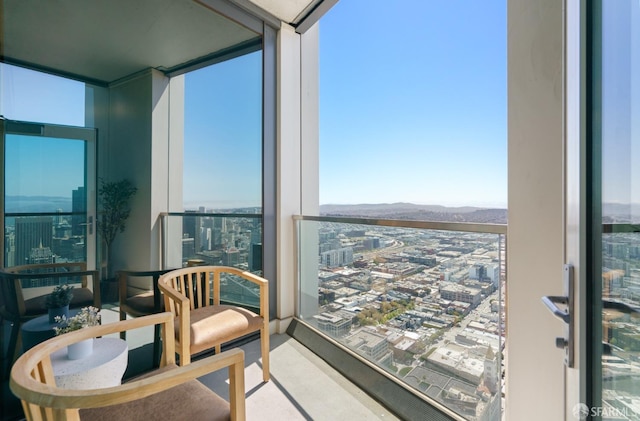 sunroom featuring a mountain view and a city view