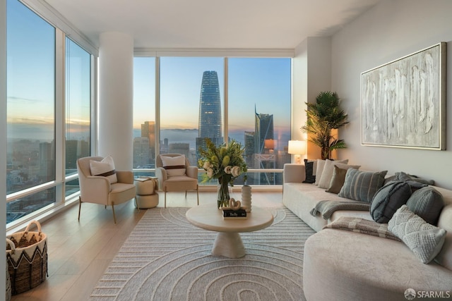 living area featuring floor to ceiling windows, a city view, and wood finished floors