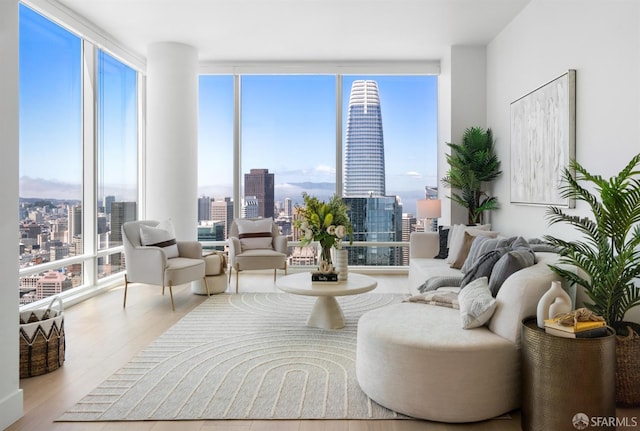 living area featuring floor to ceiling windows, a city view, and wood finished floors