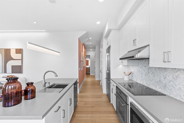 38 Steiner St Unit 303, San Francisco, CA 94114 - kitchen with stainless steel appliances, under cabinet range hood, light wood-style floors, backsplash, and recessed lighting