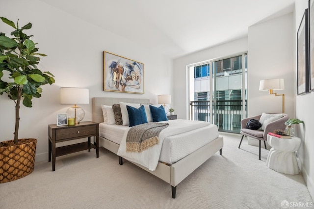 bedroom featuring access to exterior and light carpet