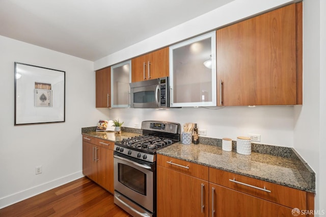 50 Lansing St Unit 403, San Francisco, CA 94105 - kitchen featuring stainless steel appliances, baseboards, dark wood finished floors, dark stone countertops, and glass insert cabinets