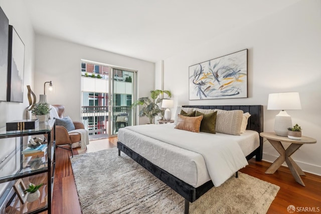 bedroom with dark hardwood / wood-style floors and access to outside