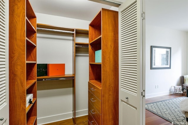 spacious closet with dark hardwood / wood-style flooring