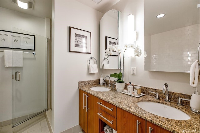 bathroom featuring tile patterned flooring, an enclosed shower, and vanity