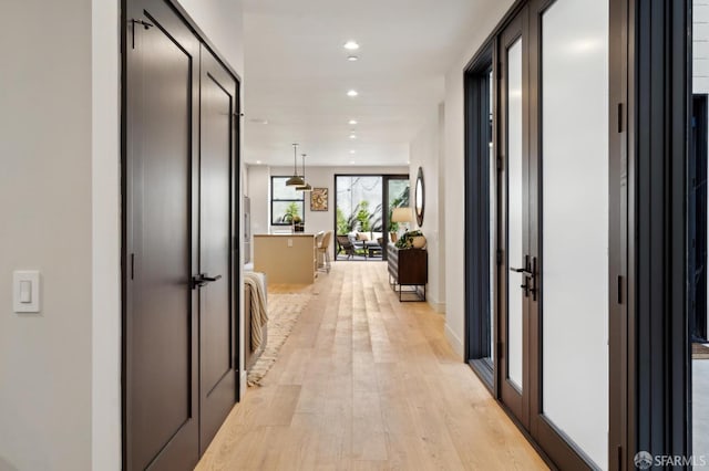 corridor featuring light wood-style flooring and recessed lighting