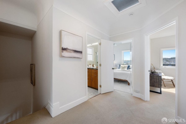 hallway featuring ornamental molding, visible vents, light carpet, and baseboards