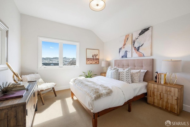 carpeted bedroom with lofted ceiling and baseboards