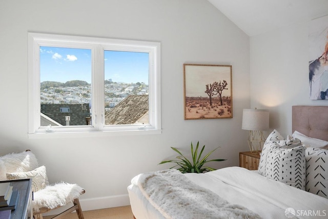 bedroom featuring lofted ceiling and baseboards