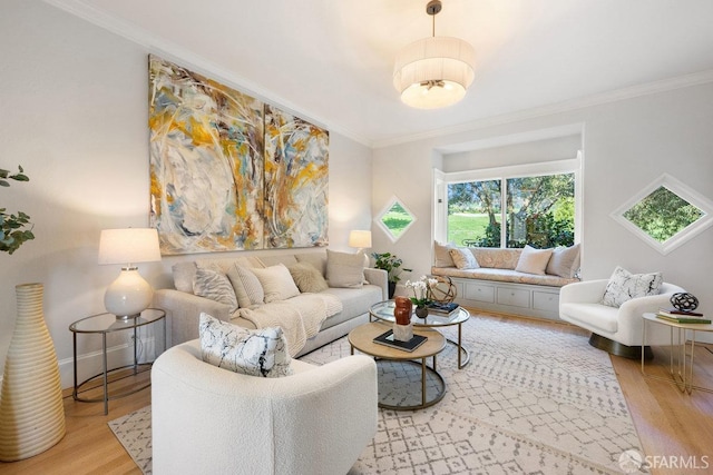 living room featuring crown molding, baseboards, and wood finished floors