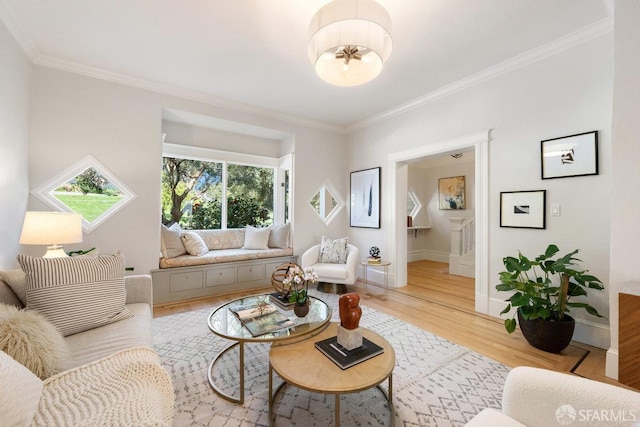 living room featuring baseboards, light wood-type flooring, and crown molding