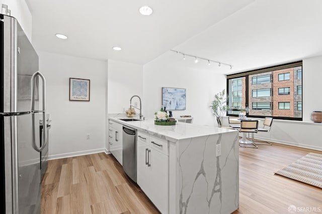 250 King St Unit 536, San Francisco, CA 94107 - kitchen with stainless steel appliances, a peninsula, light wood-style flooring, white cabinetry, and rail lighting