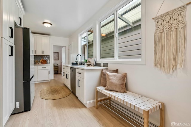 1210 40th Ave, San Francisco, CA 94122 - kitchen featuring freestanding refrigerator, light wood-style floors, stainless steel dishwasher, and white cabinets