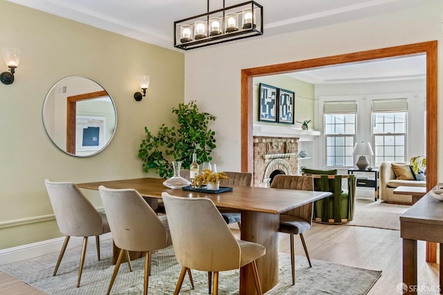 1210 40th Ave, San Francisco, CA 94122 - dining area featuring light wood-type flooring, a fireplace, and a chandelier