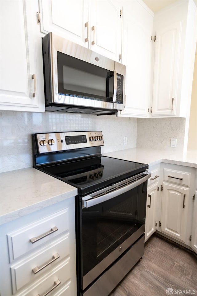 kitchen featuring wood finished floors, white cabinets, and stainless steel appliances