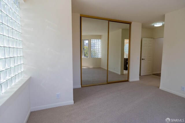 unfurnished bedroom featuring a closet, baseboards, and carpet