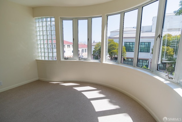 carpeted empty room featuring baseboards